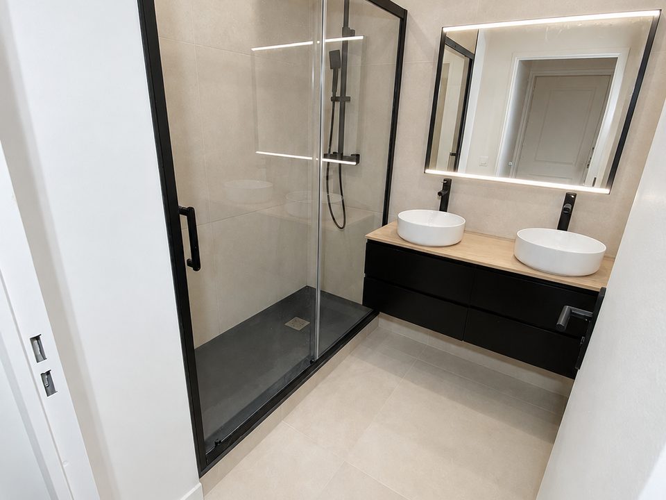Salle de bains rénovée avec douche vitrée et meuble double vasque